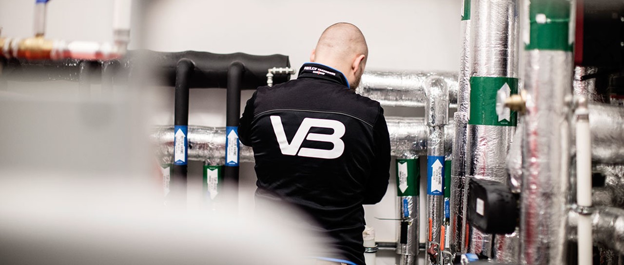 VB rørlegger i arbeid. VB logo på arbeidsjakke.